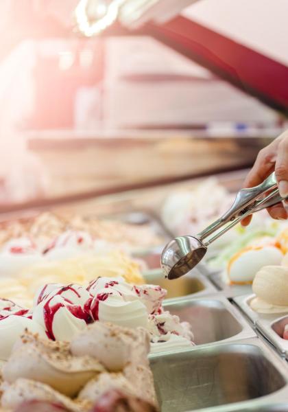 Mano che serve gelato in una gelateria.
