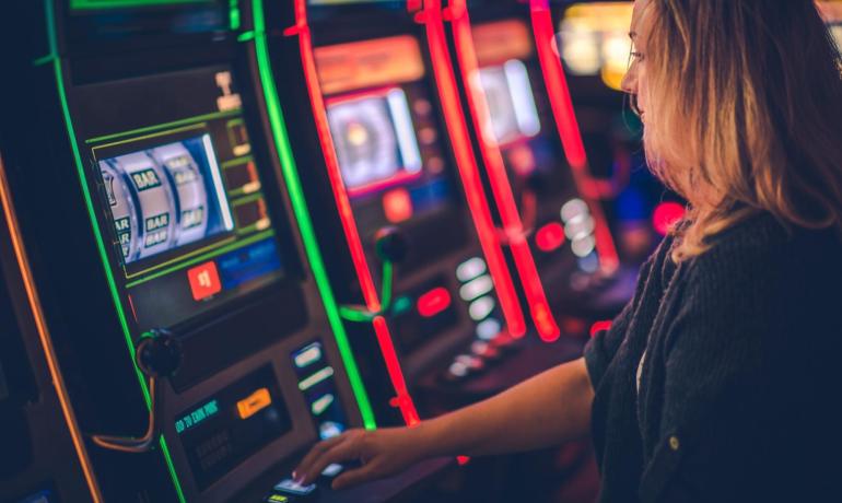 Donna gioca alle slot machine in un casinò.