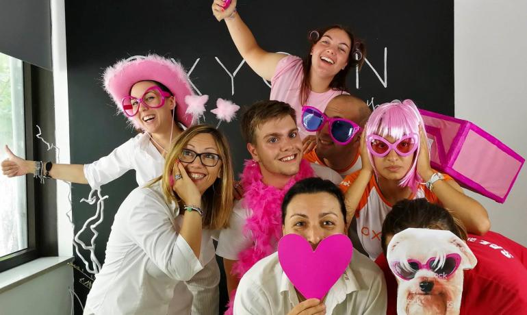 Gruppe von Menschen in rosa Kostümen, lächelnd und fröhlich.