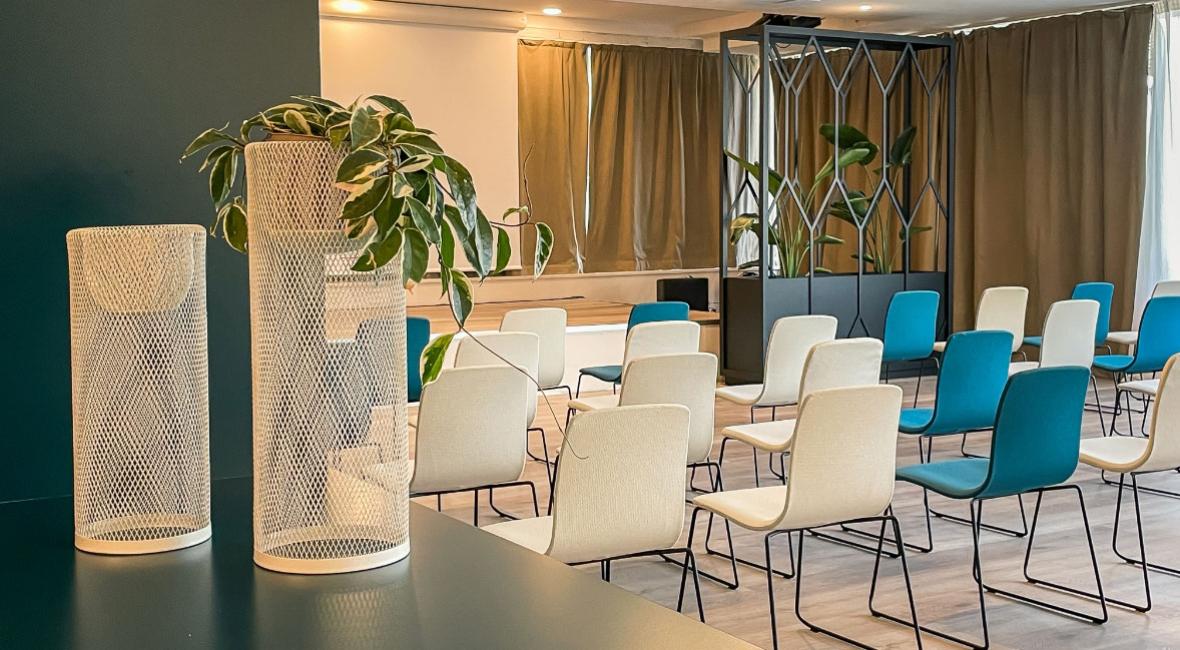 Modern conference room with colorful chairs and green decorations.