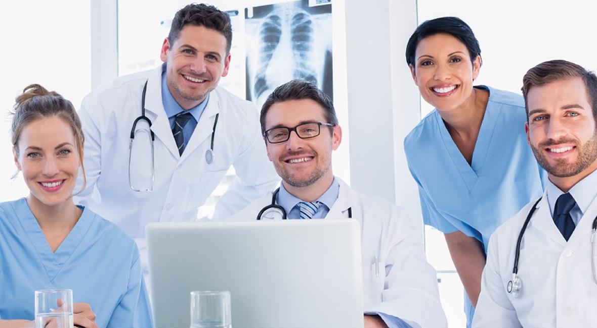 Lächelnde Gruppe von Ärzten und Krankenschwestern im Krankenhaus.