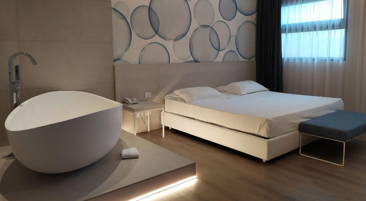 Modern room with double bed, bathtub, and bubble decorations.