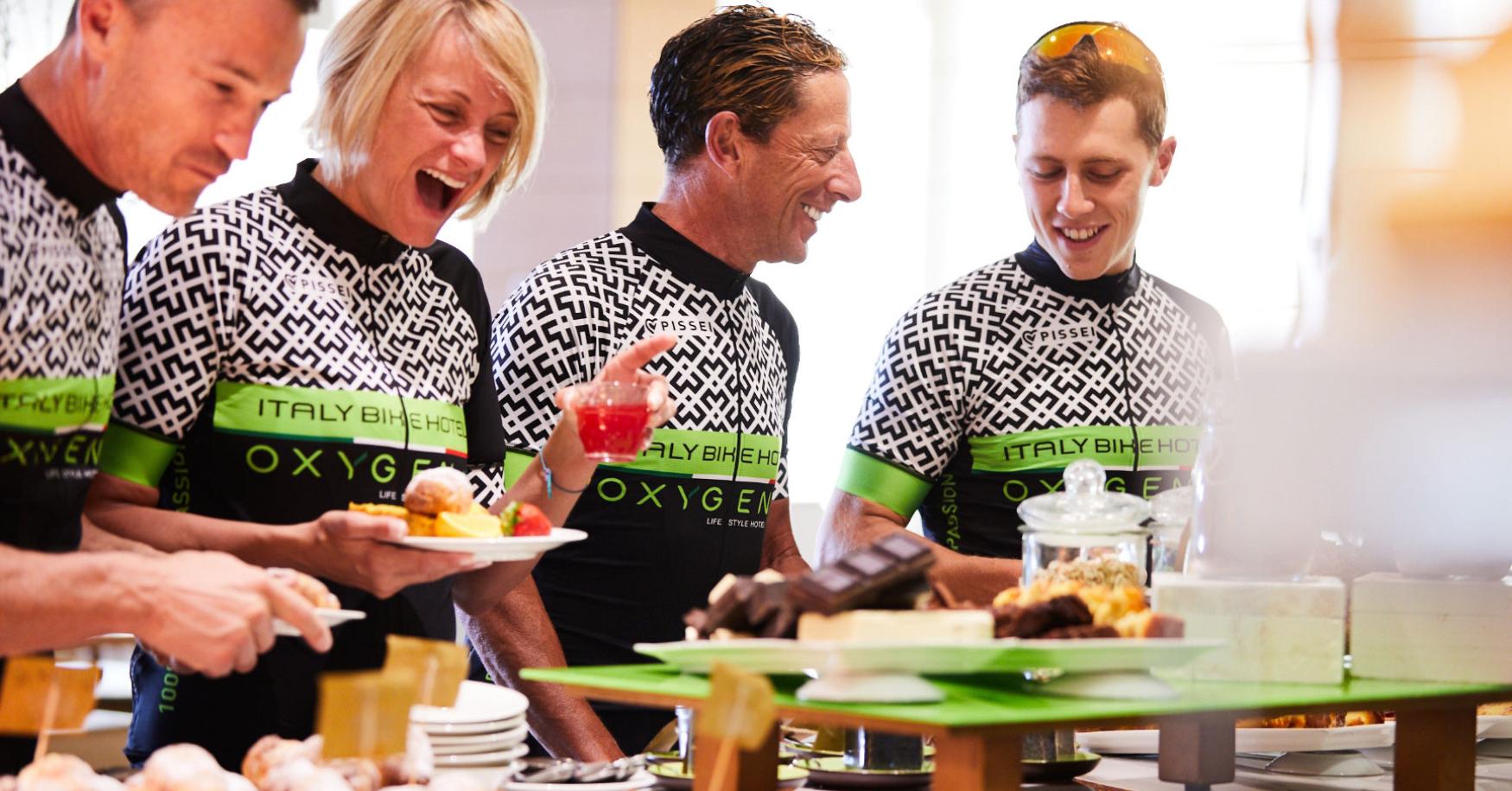 Group of cyclists enjoying a buffet at a hotel.