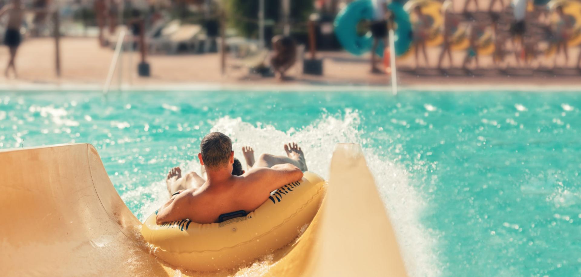 Persone su un gommone scivolano in piscina.