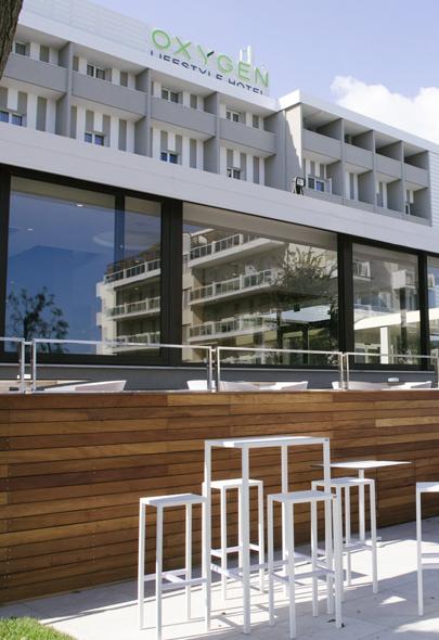 Moderno hotel con terrazza esterna e arredi bianchi minimalisti.