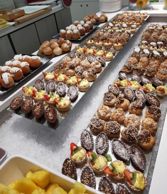 A dessert buffet with assorted pastries, fruit, and chocolate.