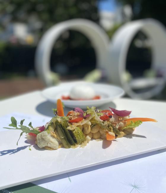 Gemischtes Gemüsegericht mit Kichererbsen und Mozzarella in einer Außenumgebung.