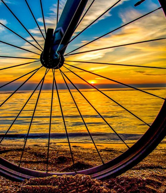 Fahrradreifen bei Sonnenuntergang am Strand.