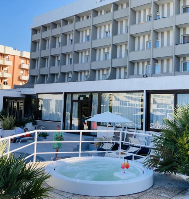 Hotel moderno con piscina e terrazza, ideale per relax.